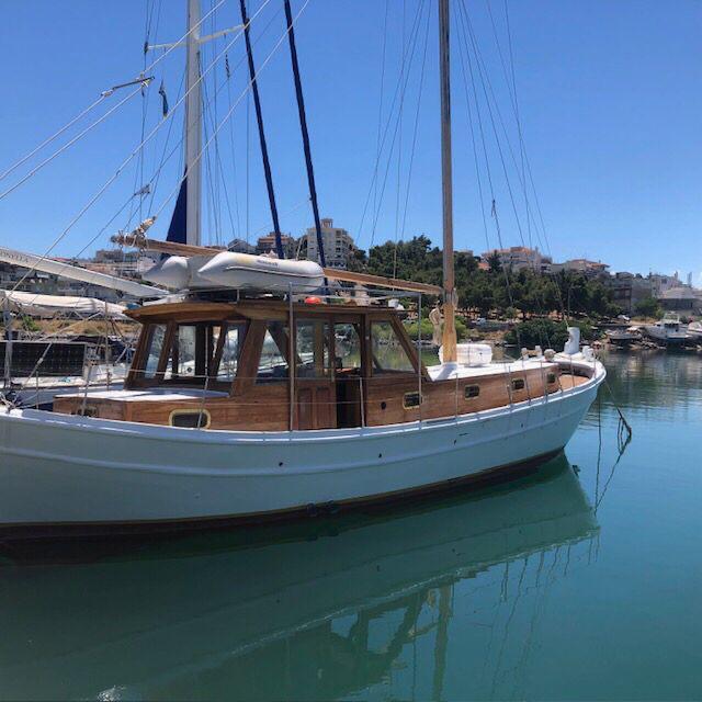 ATHINA moored in the marina, showing her white hull and wooden cabin